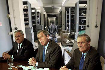 The
                  US braintrust, Powell, Bush, and Rumsfeld looking
                  self-satisfied before the destroyed inside of the
                  greatest museum of Mesopotamian artifacts.